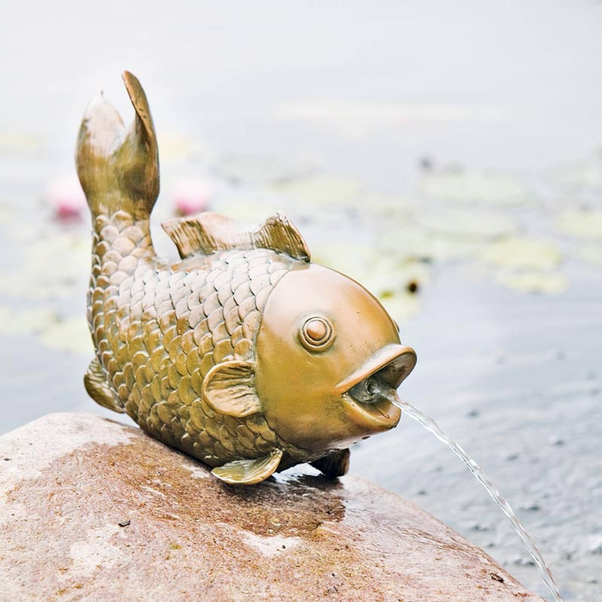 Wasserspeier goldener Fisch auf Stein sitzend